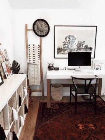 Boho Scandi otthoni tanulmány boho szőnyeggel, kosarakkal, nyomtatott textíliákkal és bojtokkal, valamint masszív fehér asztallal