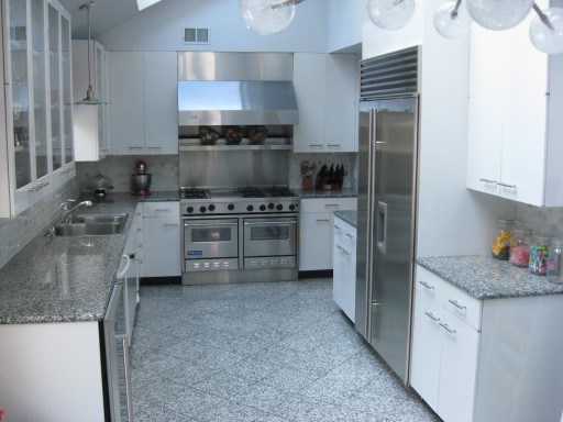 A fotó egy klasszikus tervezési lehetőséget mutat: szürke konyha és fehér bútorok.
