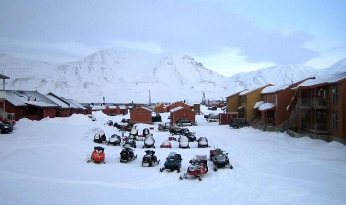 Télen, a lakosság és a turisták lépni motoros szánok (Longyearbyen, Norvégia).